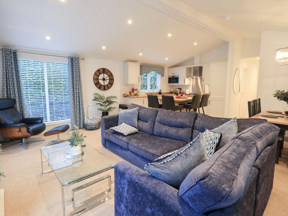 A living room with a sofa, coffee table, and dining area at Unique Luxury Lodge 1 Langdale, White Cross Bay near Windermere