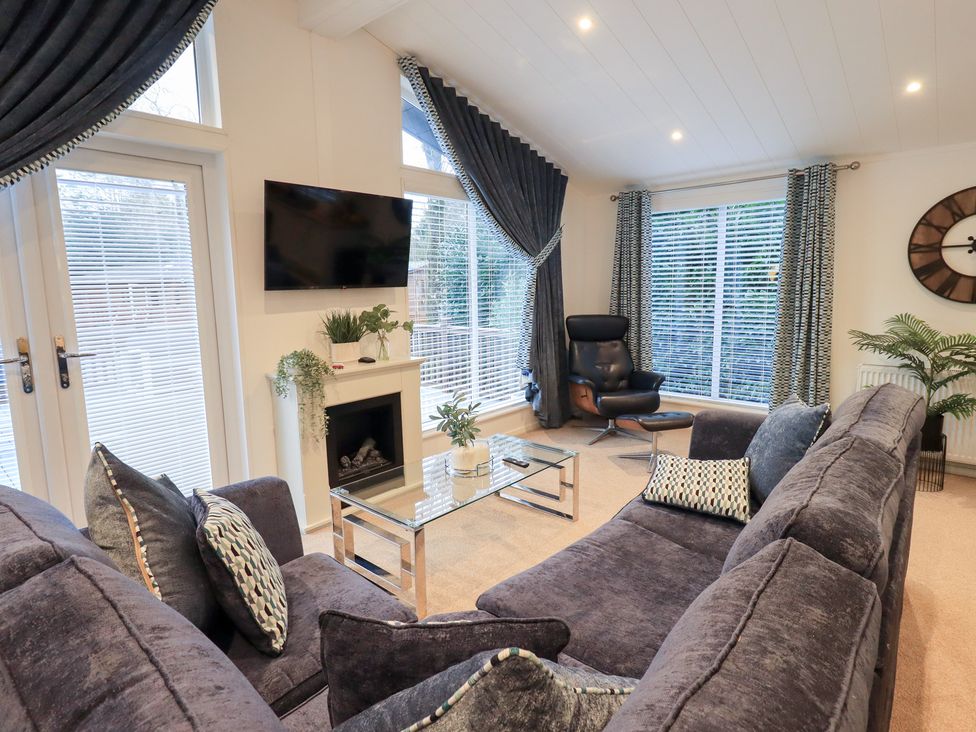 A living room with a sofa and television at Unique Luxury Lodge 1 Langdale, White Cross Bay near Windermere