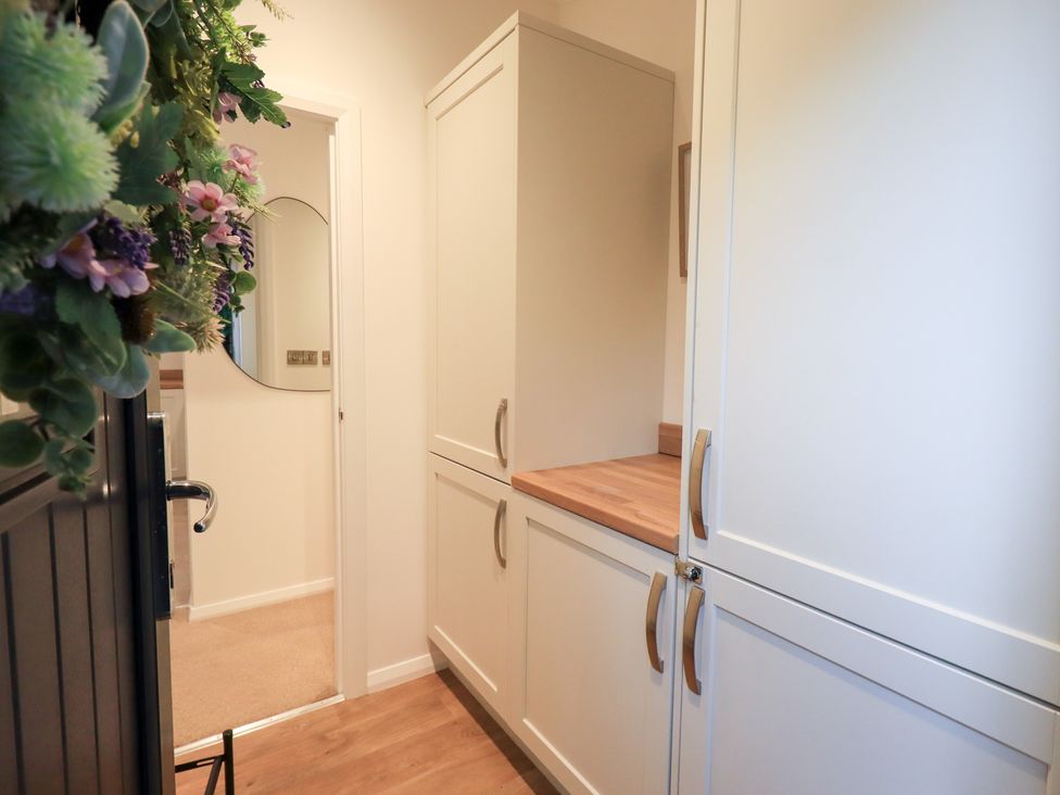 A hallway with cabinets and a mirror at Unique Luxury Lodge, 1 Langdale, White Cross Bay near Windermere