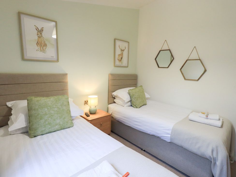 A bedroom with two beds and wall art at Unique Luxury Lodge 1 Langdale, White Cross Bay near Windermere