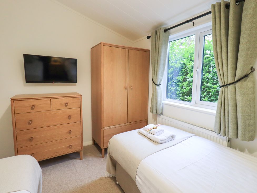 A bedroom with a bed and furniture at Unique Luxury Lodge 1 Langdale, White Cross Bay near Windermere