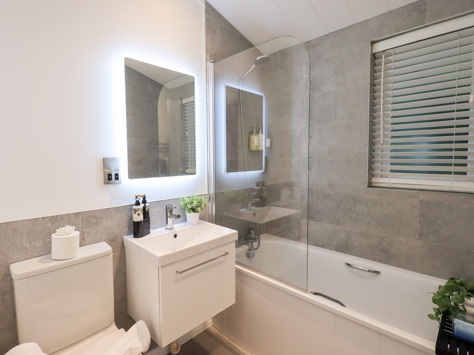 A bathroom with a sink, toilet, and bathtub at Unique Luxury Lodge, 1 Langdale, White Cross Bay near Windermere