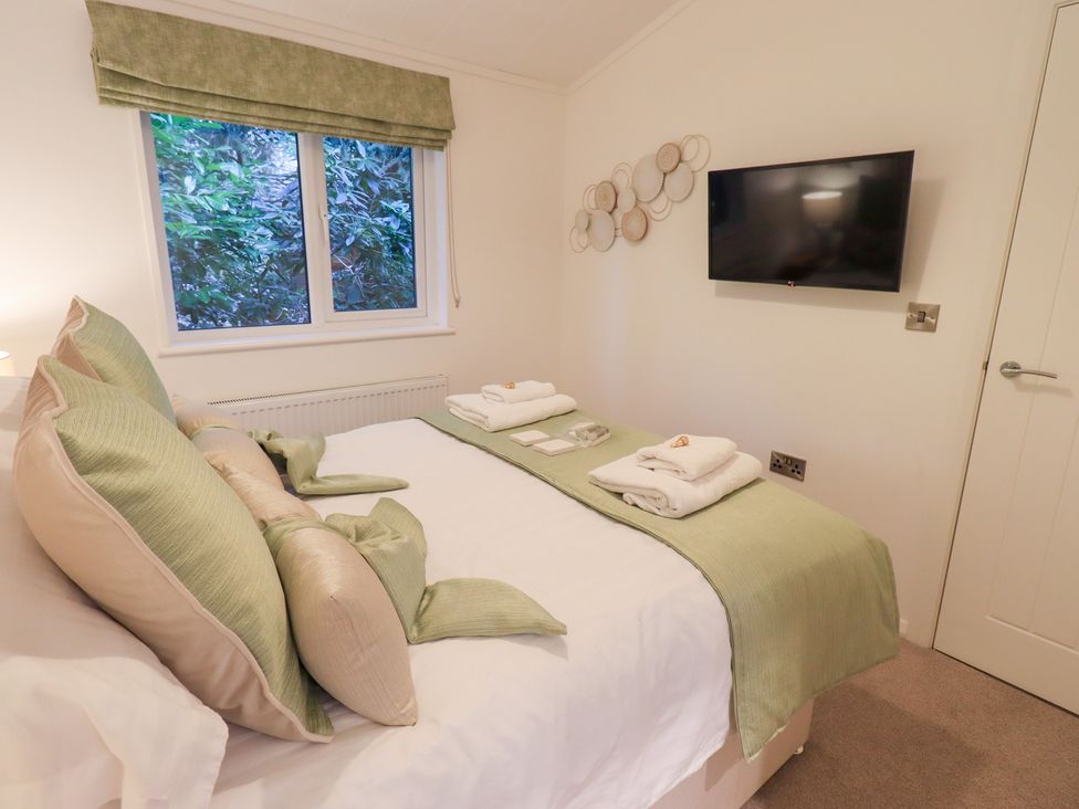 A bedroom with a bed and television at Unique Luxury Lodge, 1 Langdale, White Cross Bay near Windermere