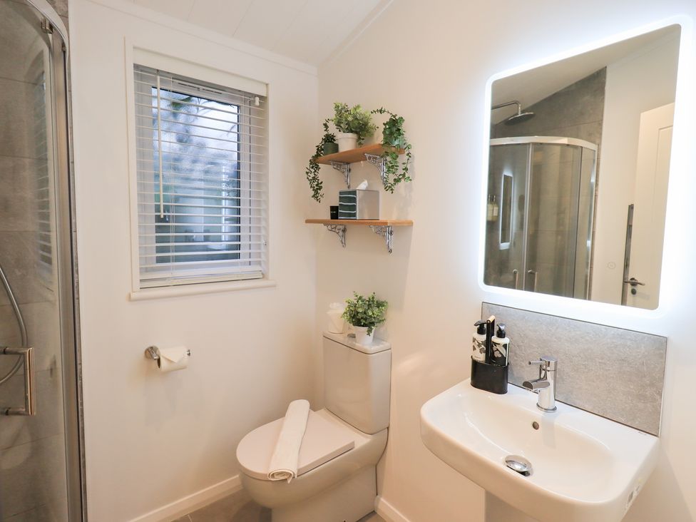 A bathroom with a shower, toilet, and sink at Unique Luxury Lodge, 1 Langdale, White Cross Bay near Windermere