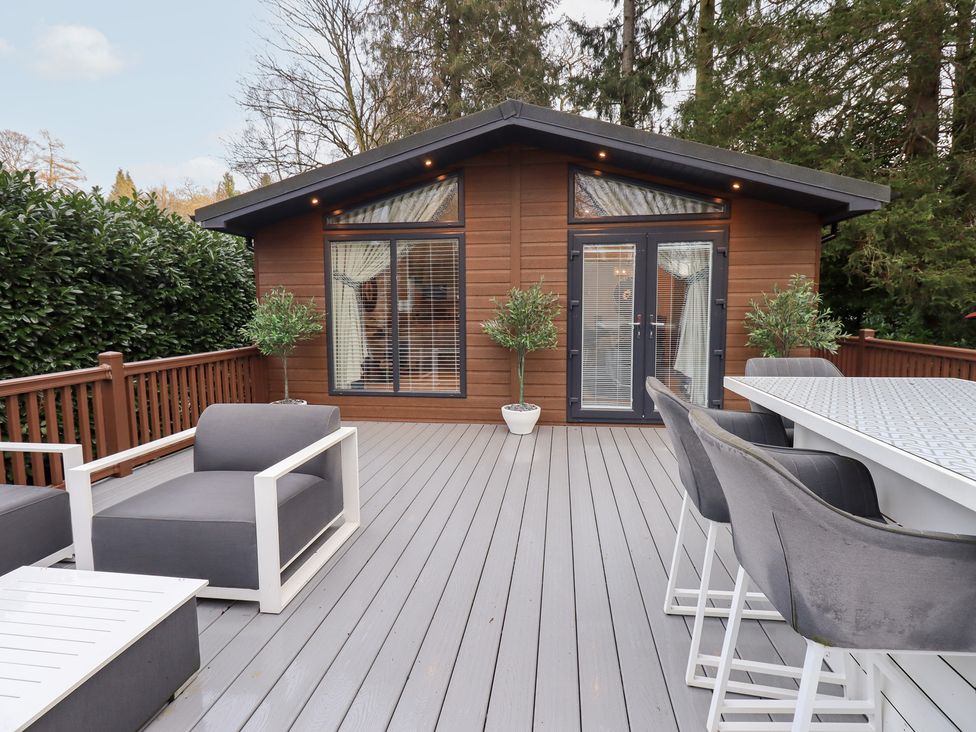 An outdoor seating area with a wooden cabin at Unique Luxury Lodge 1 Langdale, White Cross Bay near Windermere