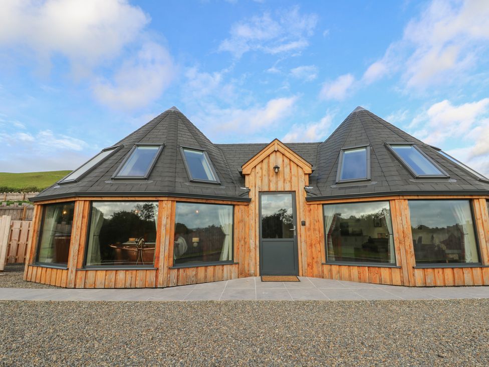 A modern house with a wooden facade and multiple windows at Ty Crwn in Lampeter