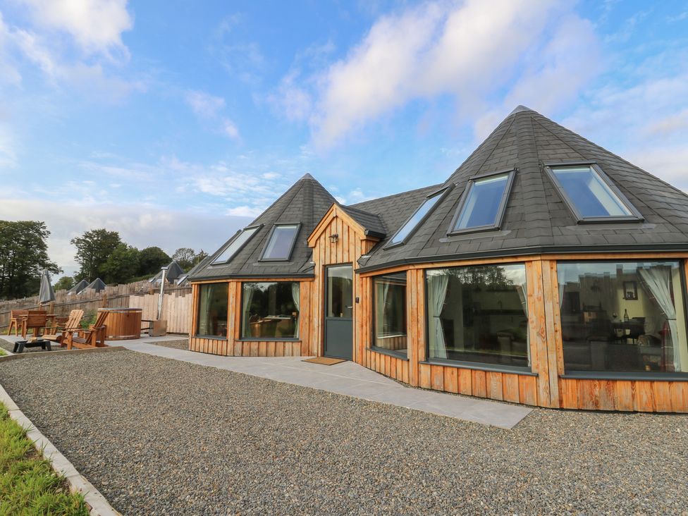 A house exterior with large windows and deck chairs at Ty Crwn in Lampeter