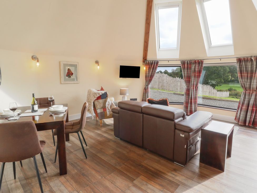 A living room with a dining area and sofa at Ty Crwn in Lampeter