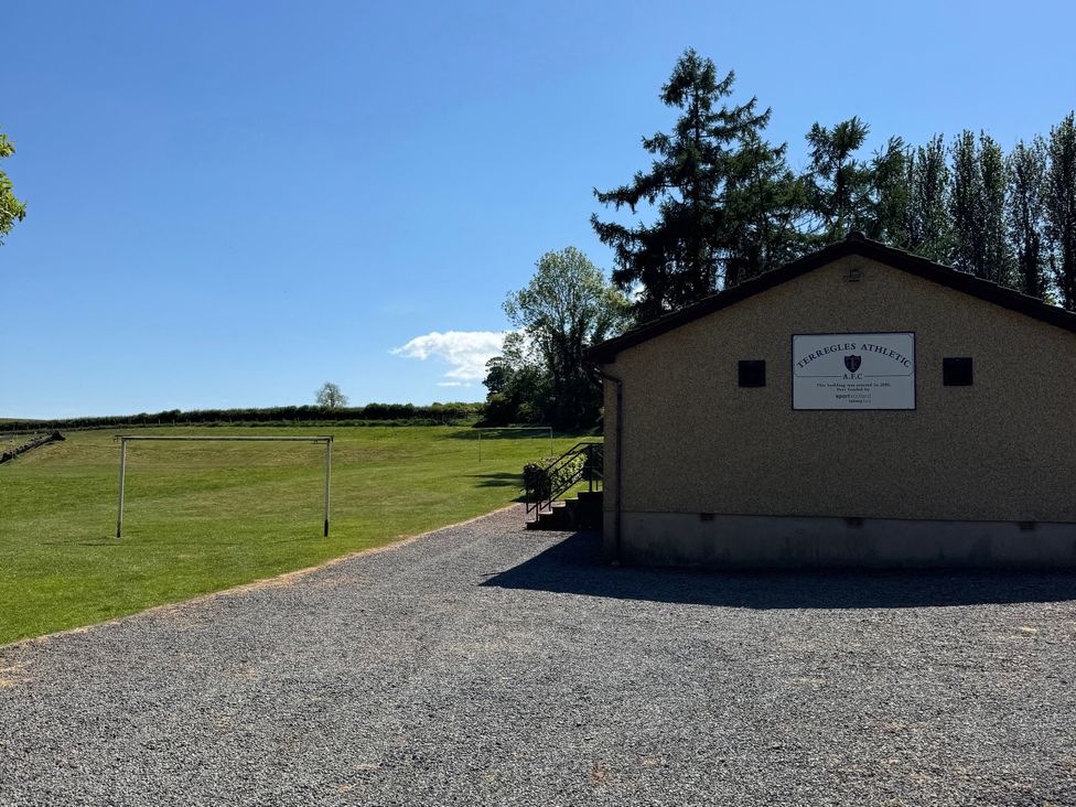 A building with a sign and soccer goals on a field at Terreggies Athletic near Dumfries