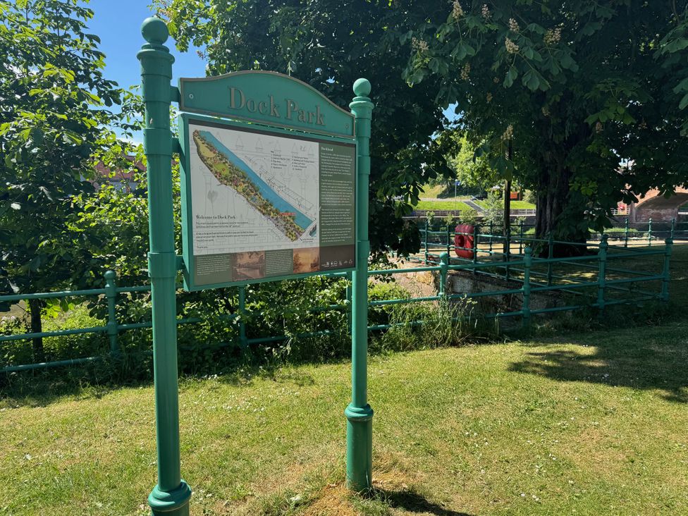A park sign at Dock Park with a map and greenery at Dock Park in Dumfries