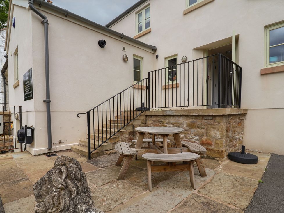 An outdoor seating area with a table and lion statue at Upstairs at the White Lion