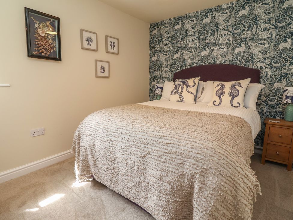 A bedroom with a bed and wall art at Upstairs at the White Lion