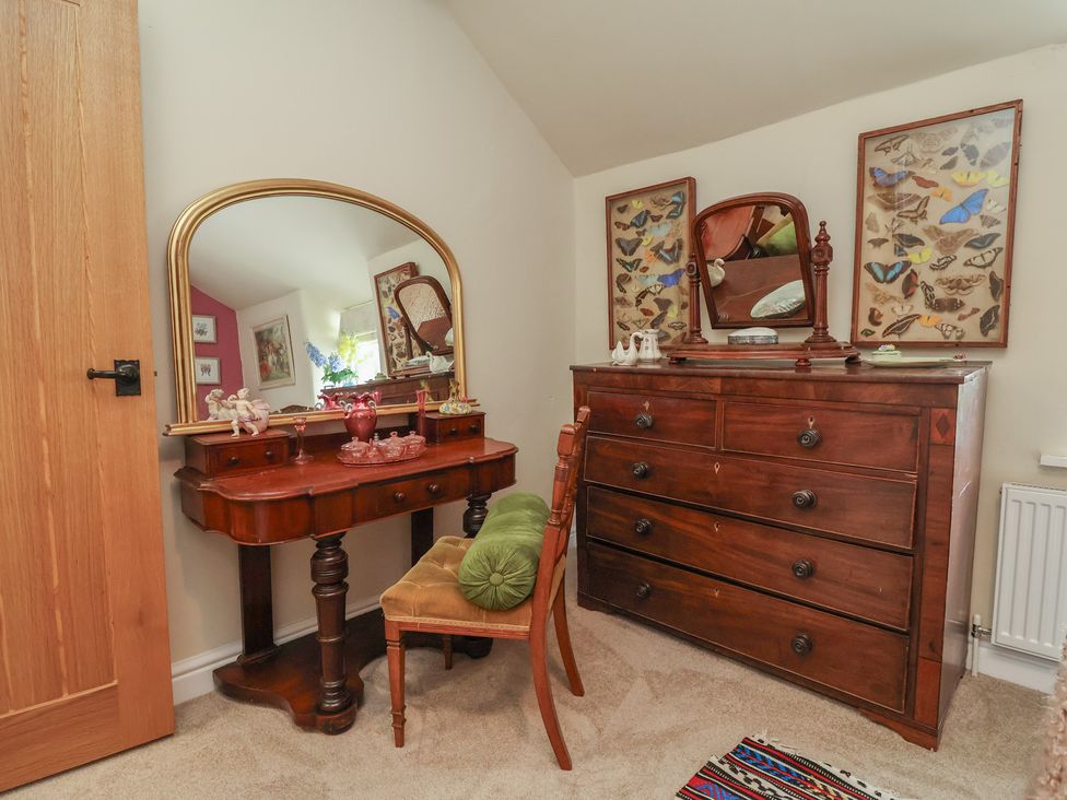 A bedroom with a dressing table and a chest of drawers at Upstairs at the White Lion