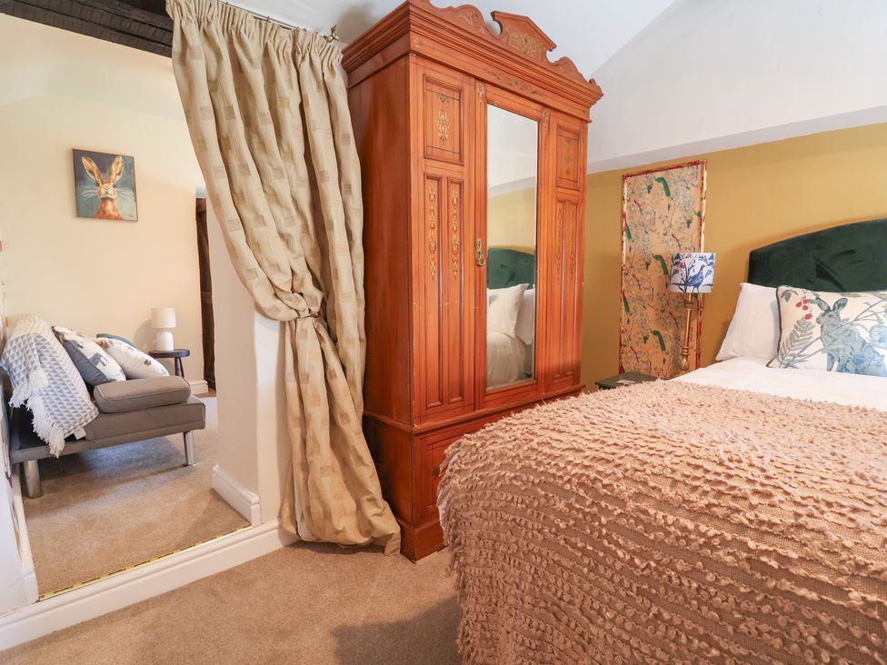 A bedroom with a bed and wardrobe at Upstairs at the White Lion 