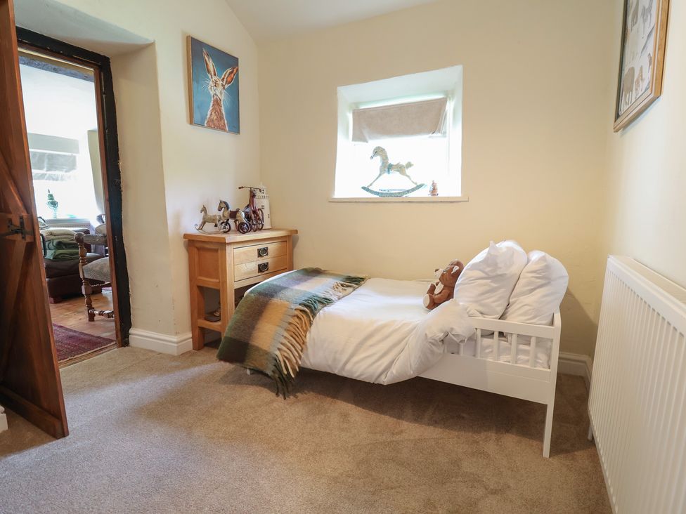 A bedroom with a bed and wooden dresser at Upstairs at the White Lion