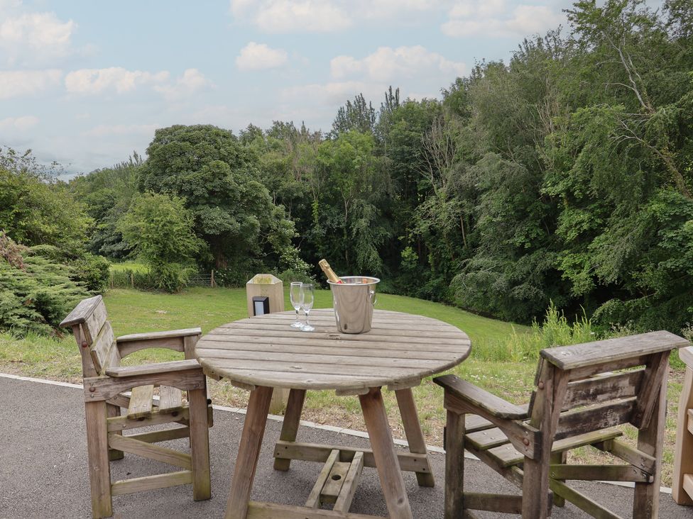 A table with chairs and a champagne bucket in a garden at Upstairs at the White Lion