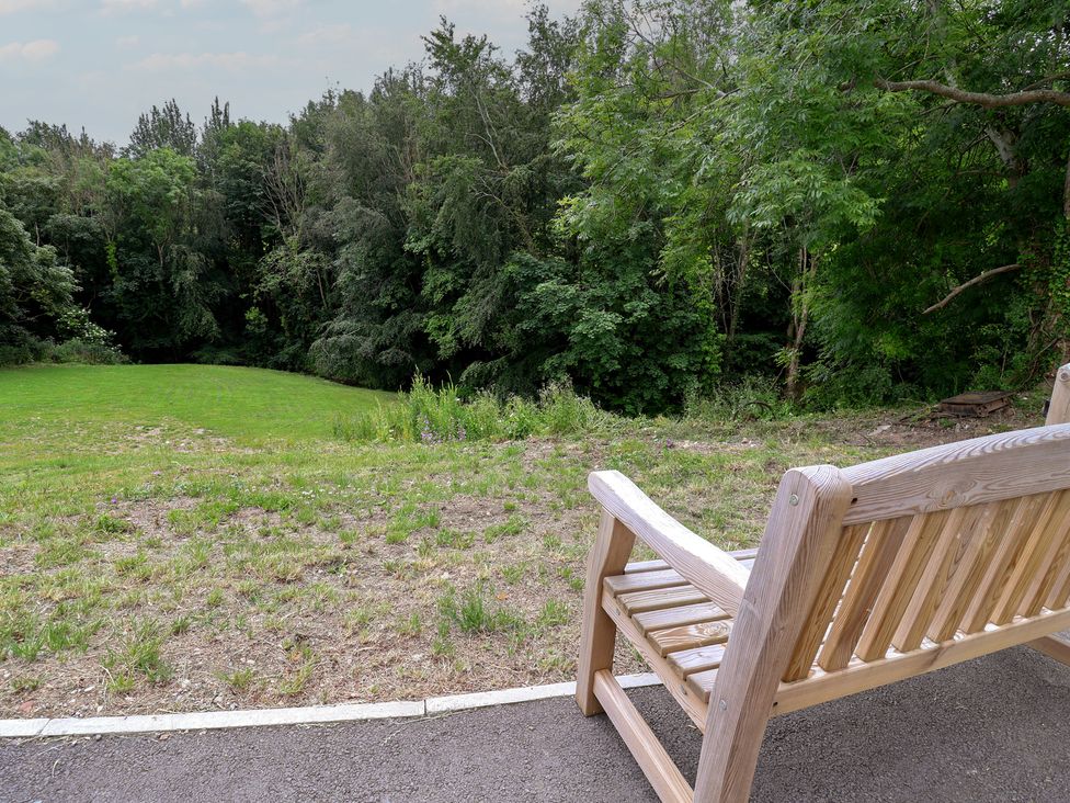 A bench overlooking a grassy area and trees at Upstairs at the White Lion in 