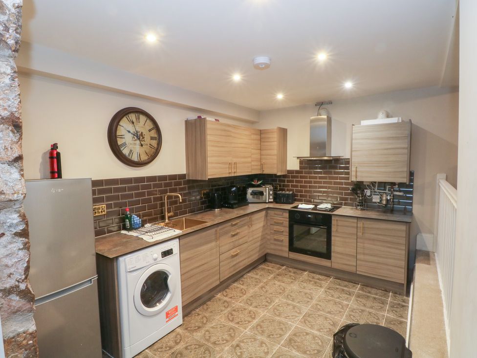 A kitchen with wooden cabinets and appliances at Lord William in Cabus near Garstang