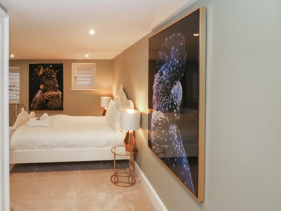 A bedroom with a bed, table, and pictures at Lord William in Cabus near Garstang