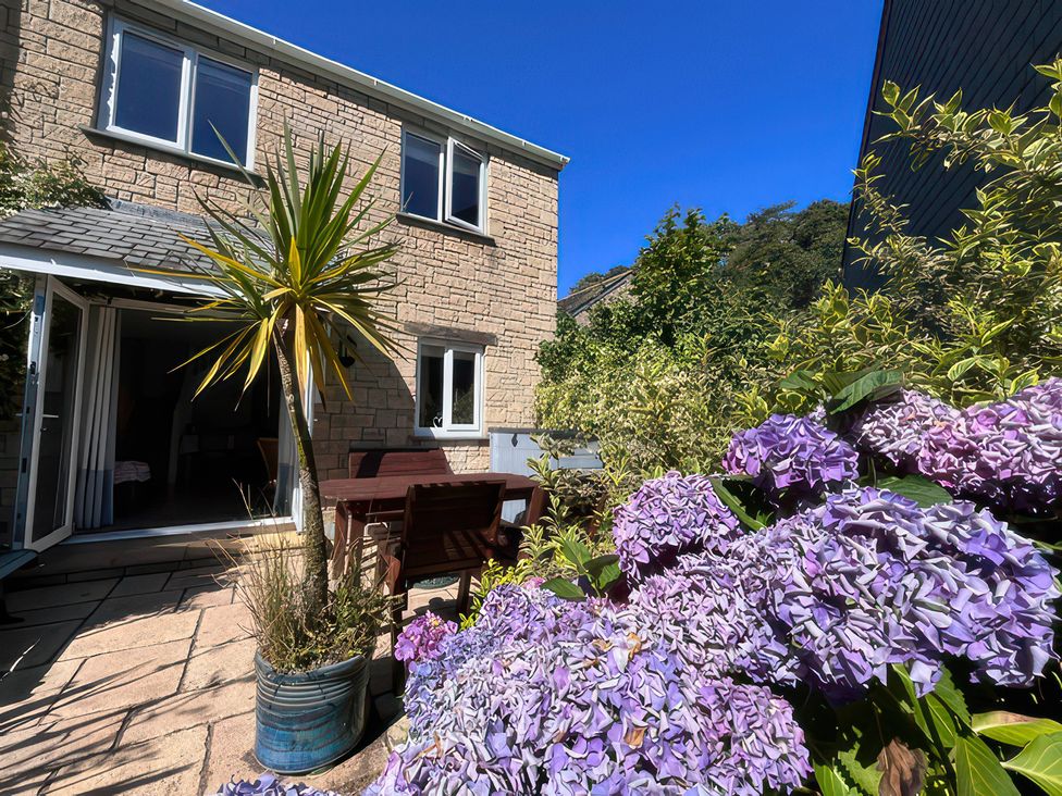 A garden with flowers and seating area at Foxglove Cottage in Falmouth