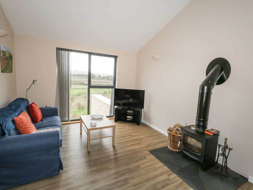 A living room with a sofa and a television at Frogwell in Yetminster