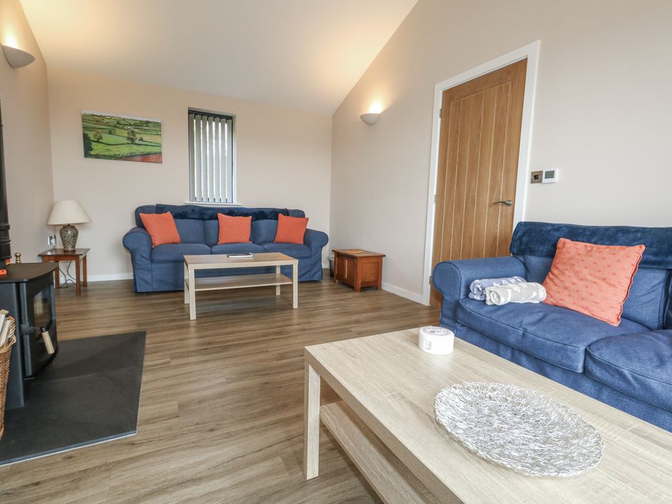 A living room with blue sofas and a coffee table at Frogwell in Yetminster