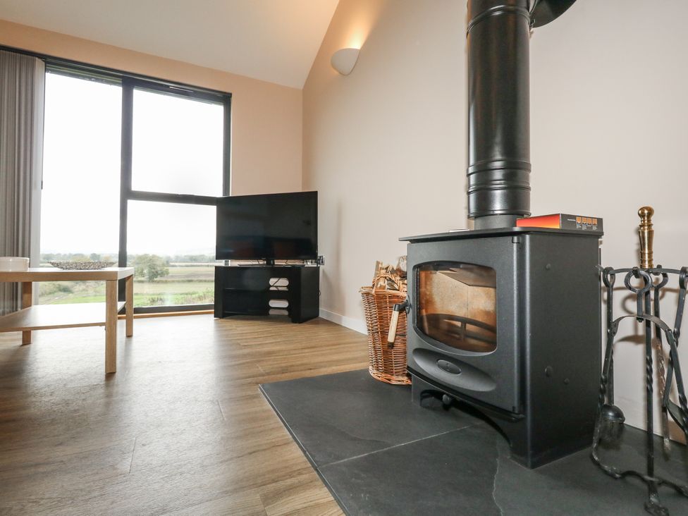A living room with a wood stove and television at Frogwell in Yetminster