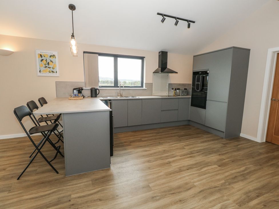 A kitchen with a counter and stools at Frogwell in Yetminster