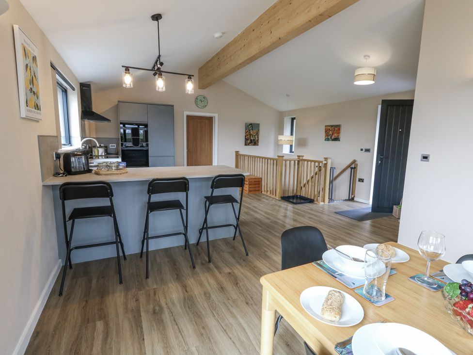 A kitchen with a dining table and bar stools at Frogwell in Yetminster