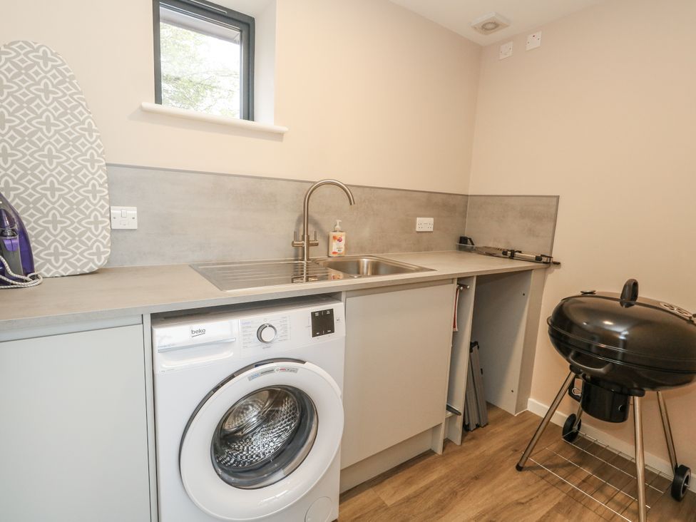 A laundry room with a washing machine and a sink at Frogwell in Yetminster