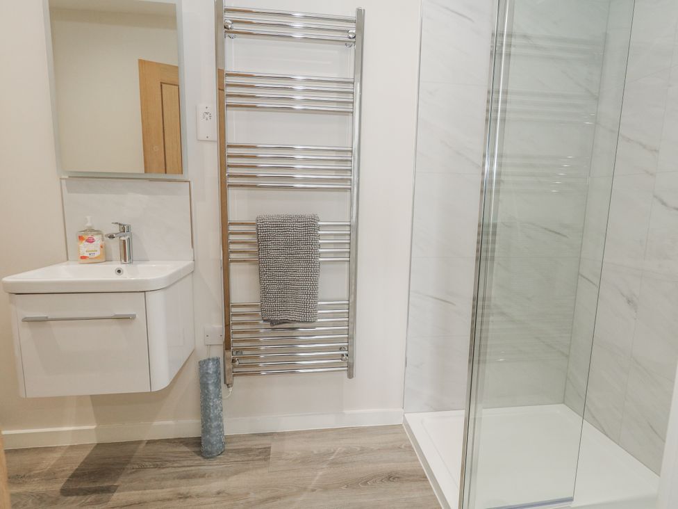 A bathroom featuring a sink, towel rail and shower at Frogwell in Yetminster