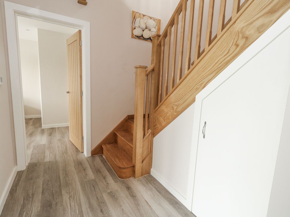 A hallway with a staircase and door at Frogwell in Yetminster