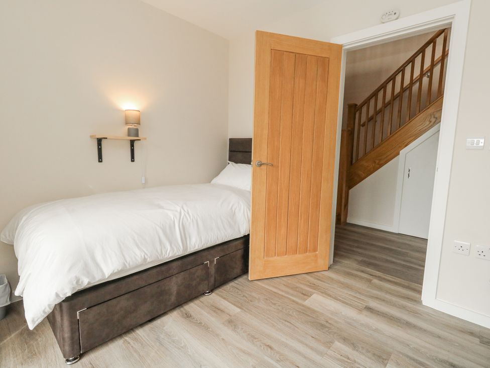A bedroom with a bed and a door leading to stairs at Frogwell in Yetminster