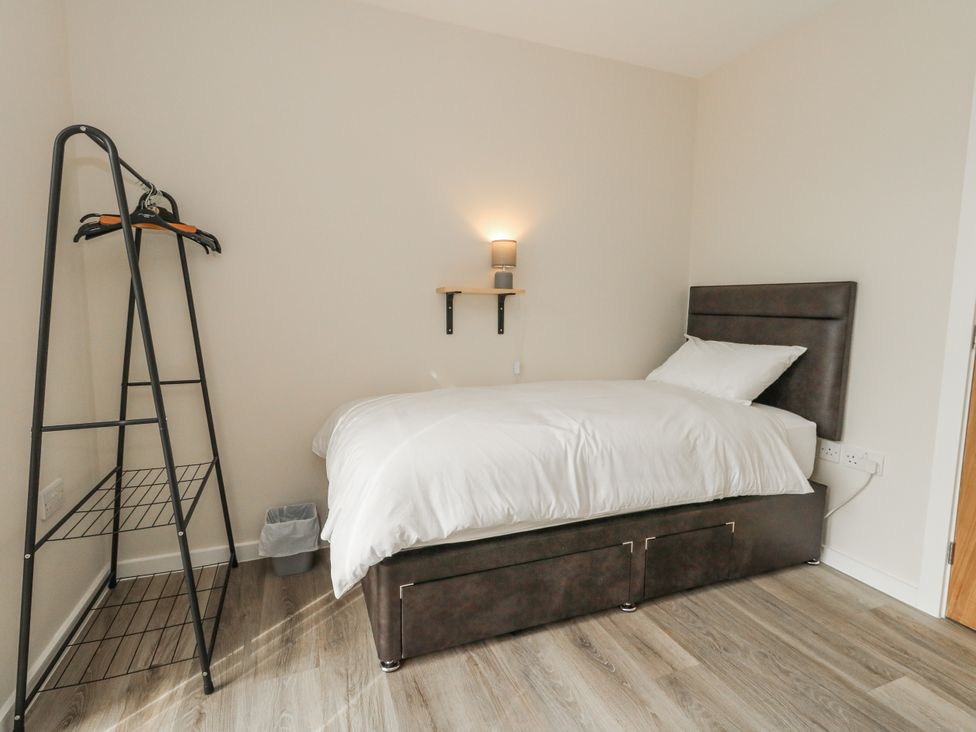 A bedroom with a bed and clothes rack at Frogwell in Yetminster