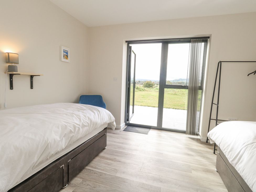 A bedroom with two beds and a door leading outside at Frogwell in Yetminster