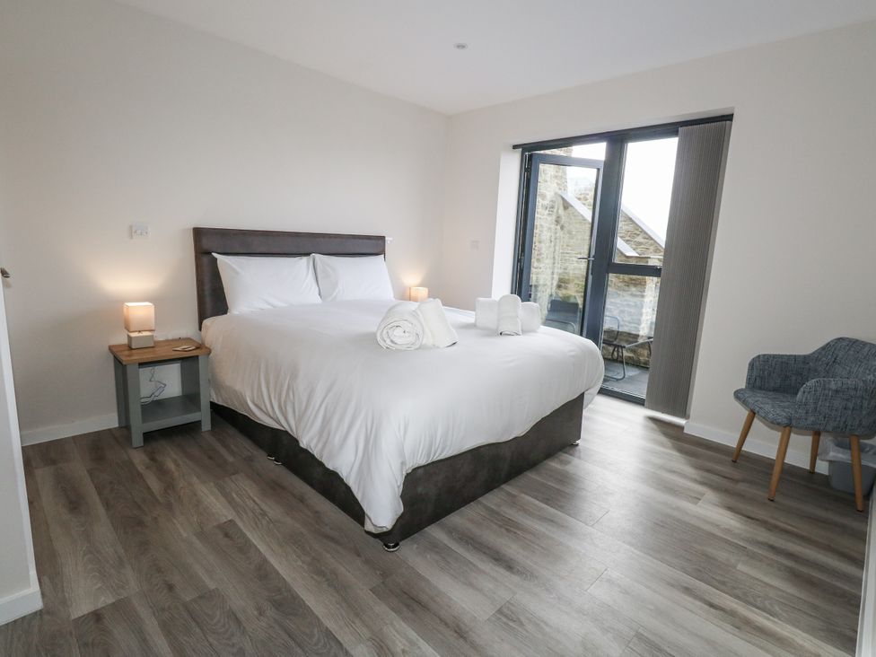 A bedroom with a bed, nightstand, and a chair at Frogwell in Yetminster