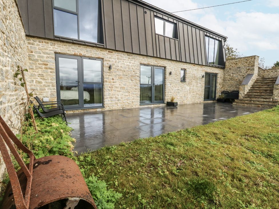 A patio with steps and a stone wall at Frogwell in Yetminster