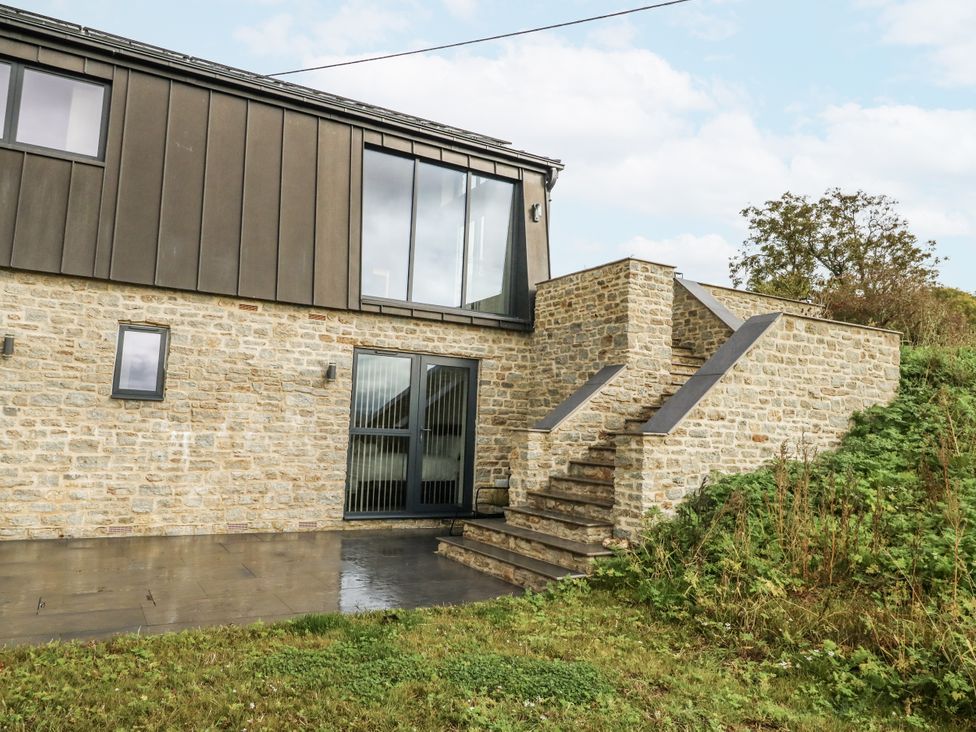 An exterior view of a house with stone walls and stairs at Frogwell in Yetminster