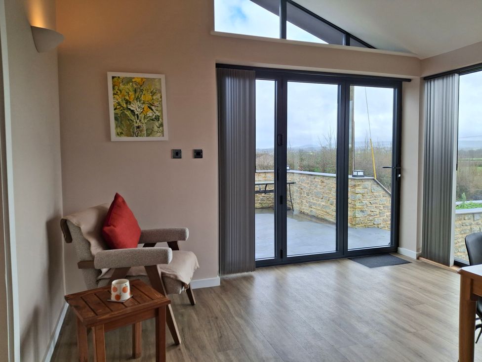 A living room with an armchair and side table at Frogwell in Yetminster