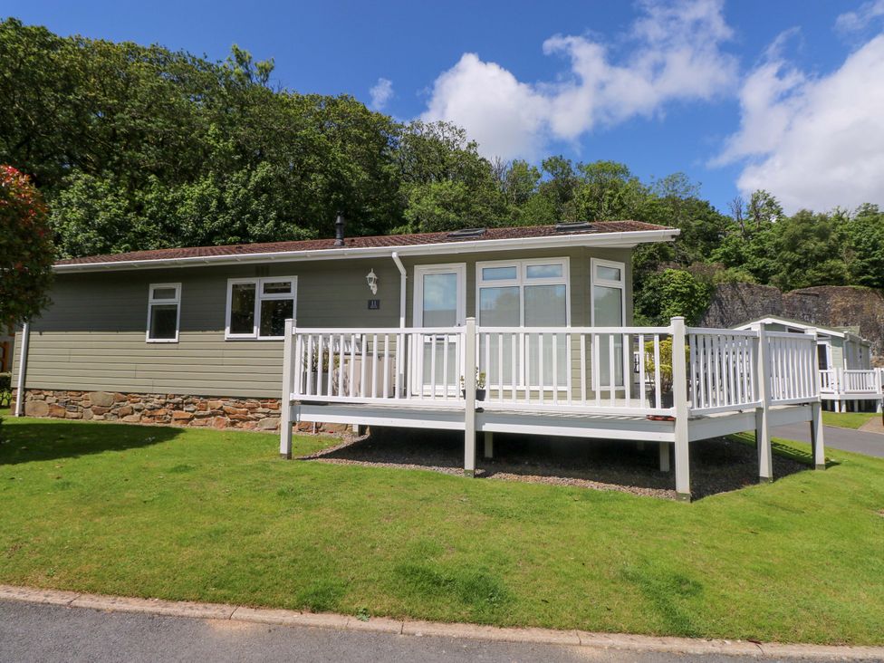 A cabin with a deck and garden at Serenity in Kilgetty