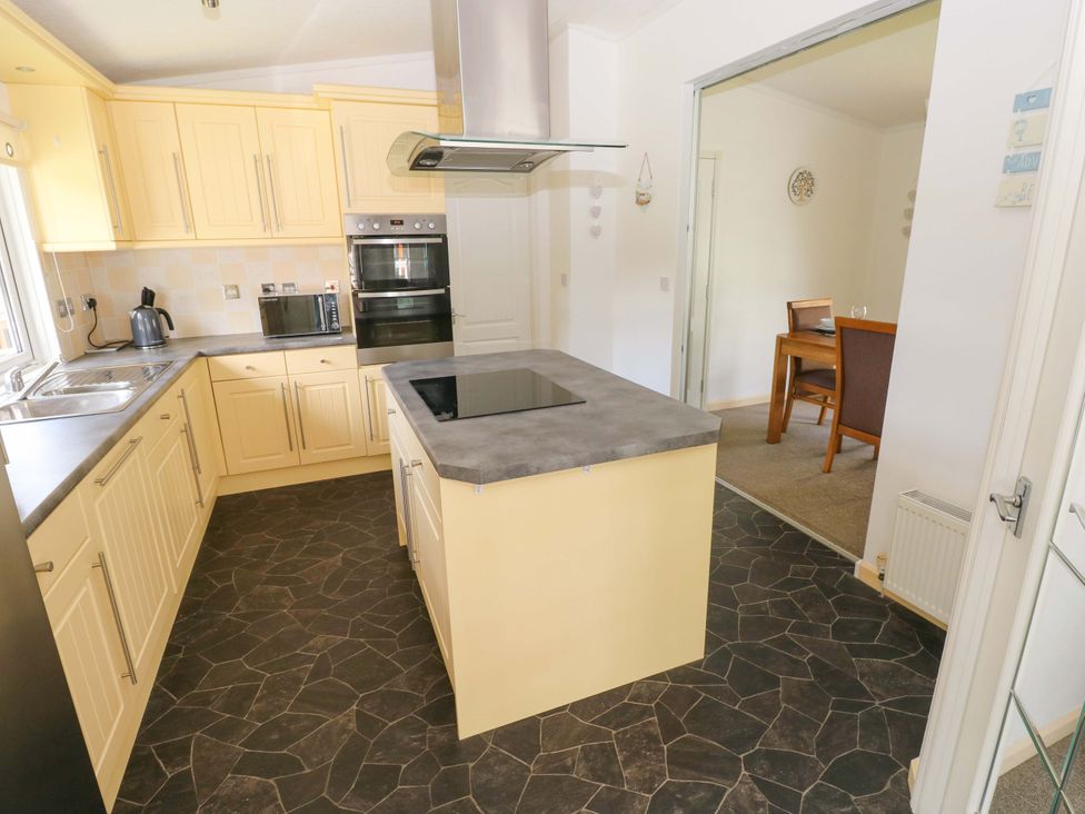 A kitchen with cabinets and appliances at Serenity in Kilgetty
