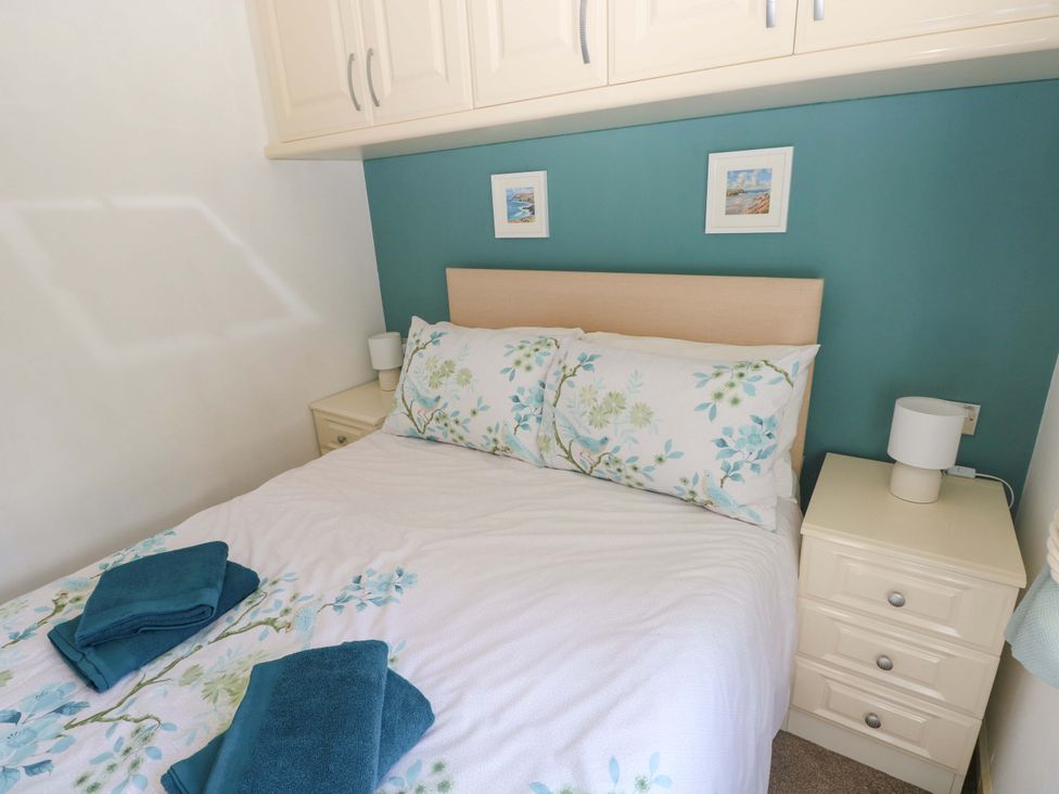 A bedroom with a bed and bedside drawers at Serenity in Kilgetty