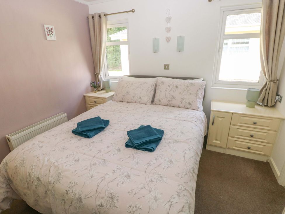 A bedroom with a double bed and bedside table at Serenity in Kilgetty