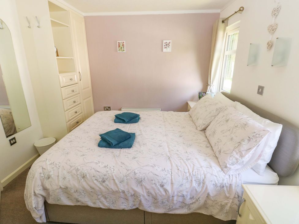 A bedroom with a bed and bedside table at Serenity in Kilgetty