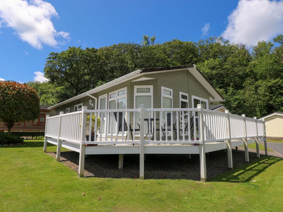 A house with a deck and surrounding trees at Serenity Stepaside near Kilgetty