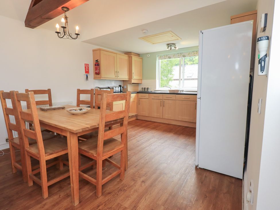 A kitchen with a dining table and chairs at Whitbarrow 24 in Penruddock