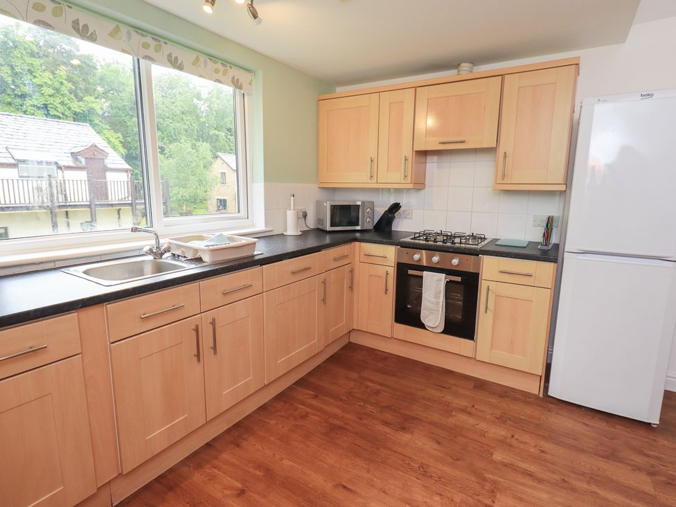 A kitchen with wooden cabinets and a sink at Whitbarrow 24 in Penruddock