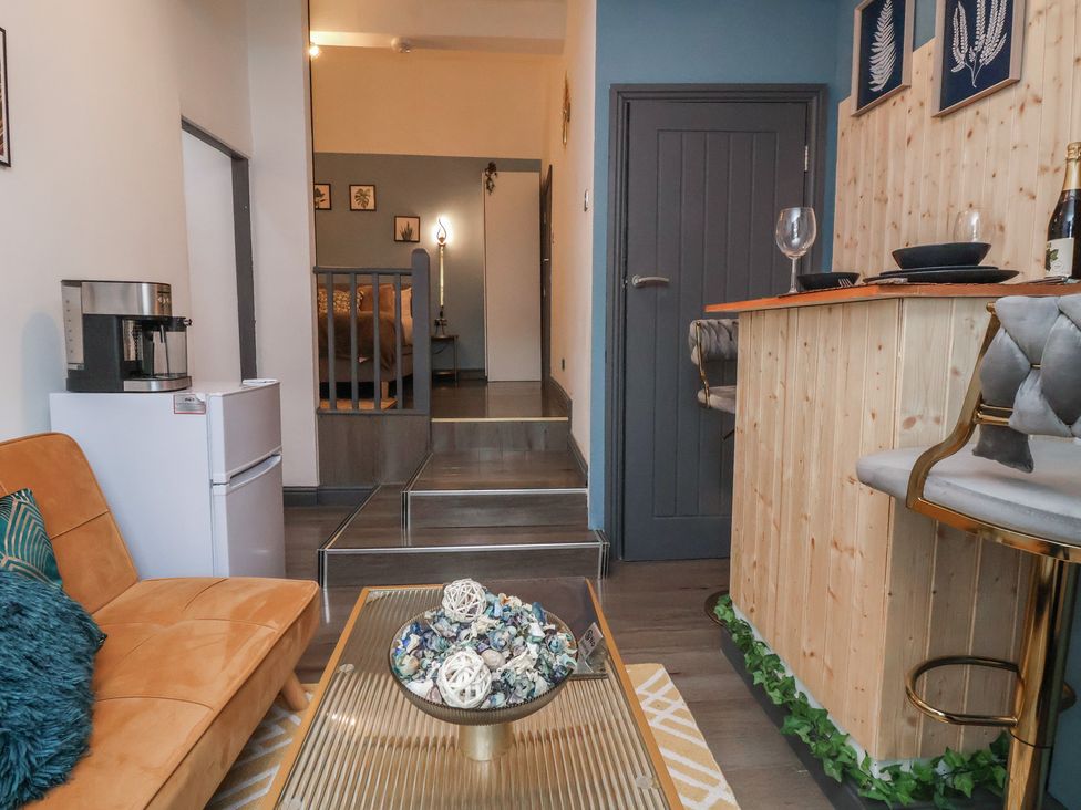 A living room featuring a sofa, bar counter, and a coffee maker at The Cloud Apartment 1 Chester