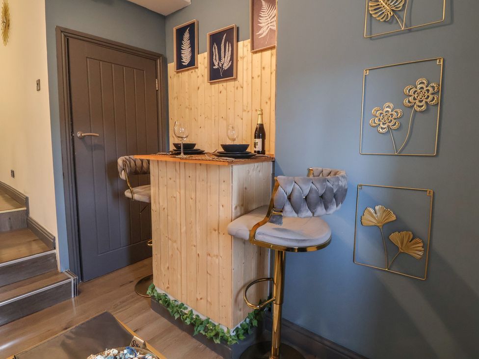 A bar area with barstools and wall art at The Cloud Apartment 1 Chester