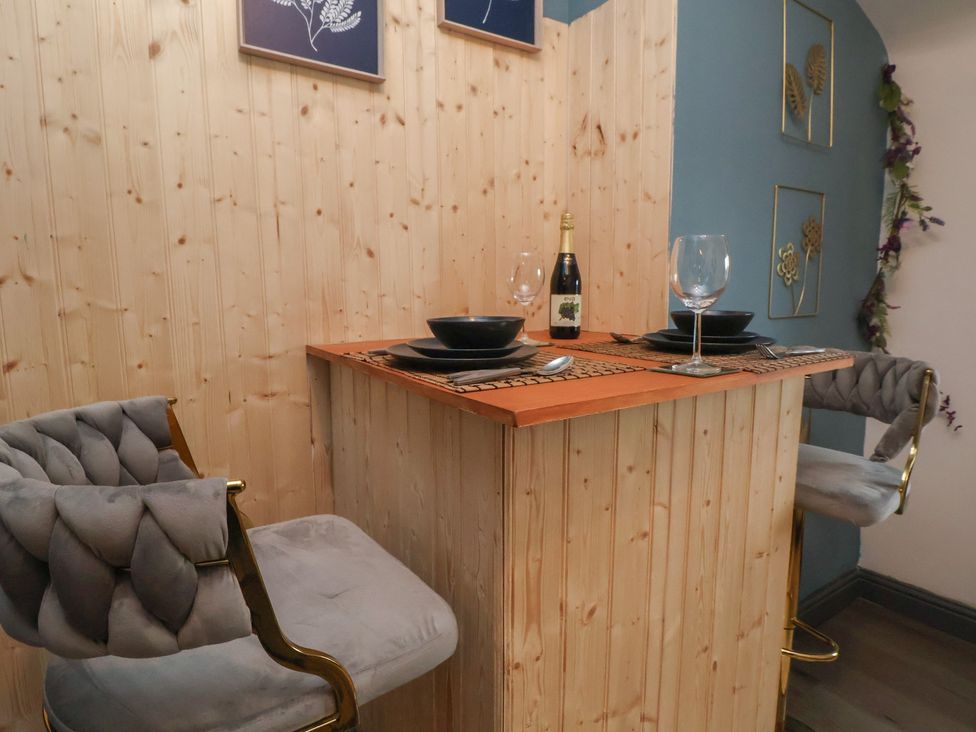 A dining area with a wooden bar and stools at The Cloud Apartment 1 Chester